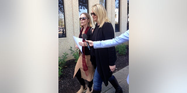 Angela Kiszko, left, walks with an unidentified woman after leaving a court house in Perth, Australia, on Friday, May 20, 2016, after a judge ruled in favor of a couple who refused to allow their 6-year-old son to undergo radiotherapy for a malignant brain tumor. Princess Margaret Hospital in Perth had applied for a Family Court order forcing Kiszko's son, Oshin, to undergo radiotherapy for a rare cancer known as medulloblastoma that was diagnosed in December.