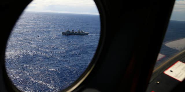 March 31, 2014: HMAS Success sails as a Royal New Zealand Air Force P3 Orion flies past while searching for missing Malaysia Airlines Flight 370 in the southern Indian Ocean.