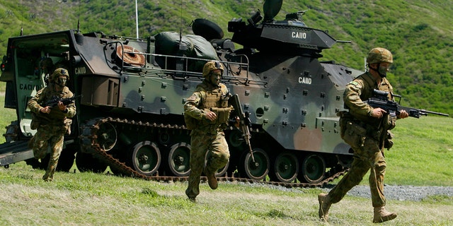 July 29, 2014: Australian Army soldiers from the 5th Battalion, Royal Australian Regiment run out of an assault amphibious vehicle (AAV) during a live fire exercise at Marine Corps Base Hawaii during the multi-national military exercise RIMPAC in Kaneohe, Hawaii.