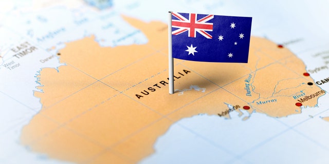 The flag of Australia pinned on the map. Horizontal orientation. Macro photography. (MarkRubens, iStock)