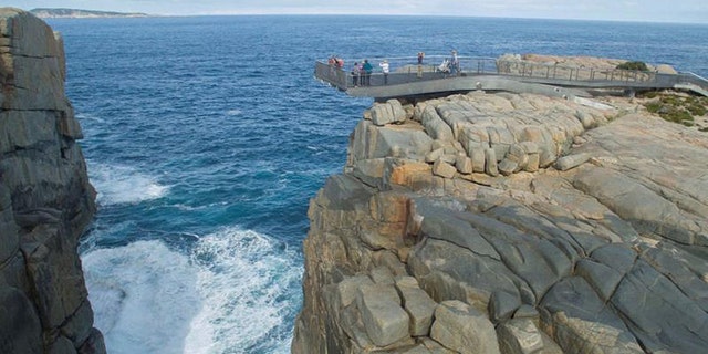 A witness reported that his friends had to be stopped from jumping off the cliff to save him