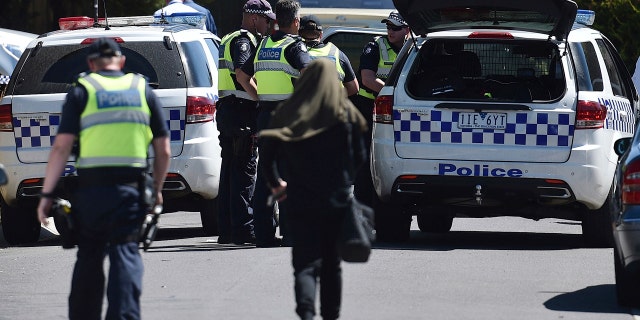 Dec. 23, 2016: Police accompany a woman as they attend the scene where a house was raided at Meadow Heights in Melbourne, Australia.