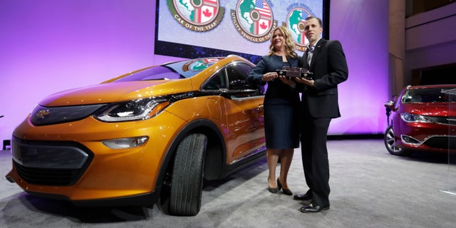 General Motors Executive Chief Engineer Autonomous & Electrified Vehicles and New Technology Pam Fletcher, left, and Bolt Chief Engineer Josh Tavel stand next to a Chevy Bolt after being named top car in the North America at the North American International Auto show, Monday, Jan. 9, 2017, in Detroit. (AP Photo/Carlos Osorio)