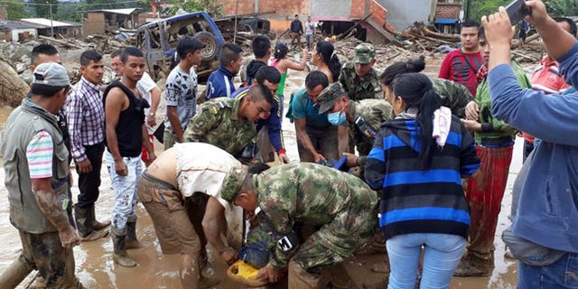 Soldiers carry a victim on a stretcher in Mocoa, Colombia, Saturday, April 1, 2017.