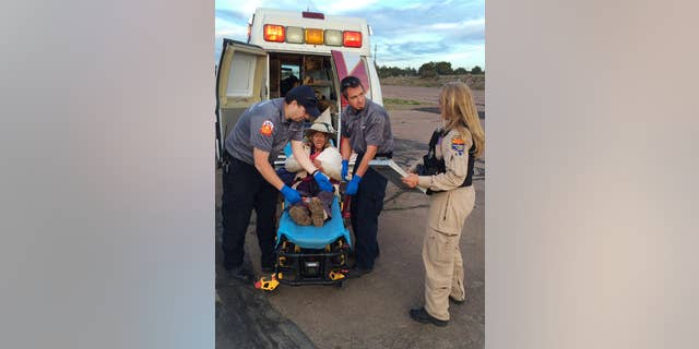 This photo taken, Saturday, April 9, 2016, and provided by Arizona Department of Public Safety shows an ambulance taking Ann Rodgers, 72 , to safety after she was lost in the forest for nine days.