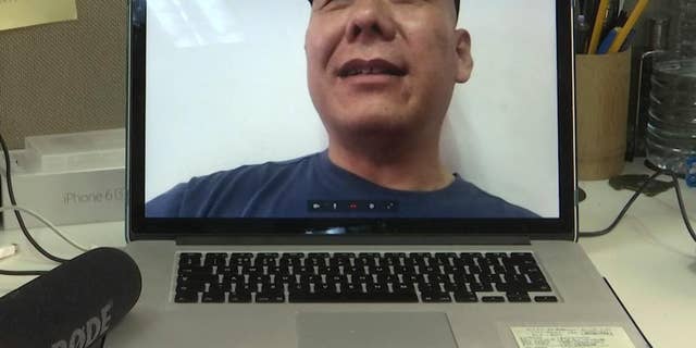 Chinese dissident Zhang Xiangzhong is seen on a computer screen during an interview via videoconference Monday, April 17, 2017, in Taipei, Taiwan. Zhang, who abandoned his tour group while in Taiwan, said he will apply for political asylum on Tuesday in hopes of staying on the self-governing island to promote democracy on the mainland. (AP Photo/Johnson Lai)