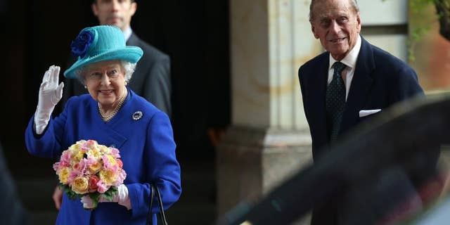 Britain's Queen Elizabeth II, left, waves as she and Prince Philip, the Duke of Edinburgh, arrive at their hotel in Germany's capital Berlin, Tuesday, June 23, 2015. Queen Elizabeth II and her husband Prince Philip are on an official visit to Germany until Friday, June 26. (Joerg Carstensen/dpa via AP)