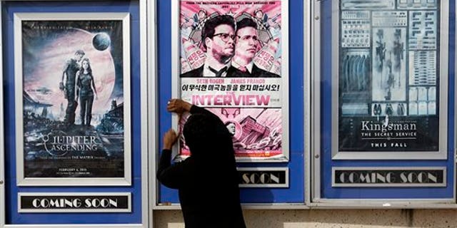 FILE - In this Wednesday, Dec. 17, 2014 file photo, a worker removes poster for the movie "The Interview" from a display case at a Carmike Cinemas movie theater in Atlanta. The Alamo Drafthouse in Texas and Atlanta's Plaza Theater on Tuesday, Dec. 23, 2014 said they will begin showing "The Interview" on Christmas Day, seemingly putting the comedy back in theaters after Sony Pictures Entertainment canceled its release. The Plaza is independently owned and not part of the Carmike chain. (AP Photo/David Goldman, File)