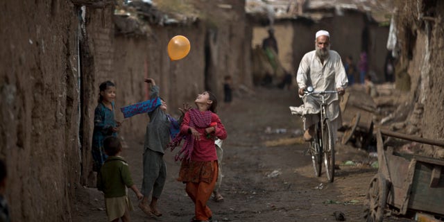 Afghan refugee children play with a balloon in an alley of a poor neighborhood on the outskirts of Islamabad, Pakistan, Thursday, Oct. 31, 2013. Pakistan hosts over 1.6 million registered Afghans, the largest and most protracted refugee population in the world, according to the U.N. refugee agency, thousands of them still live without electricity, running water and other basic services. (AP Photo/Muhammed Muheisen)