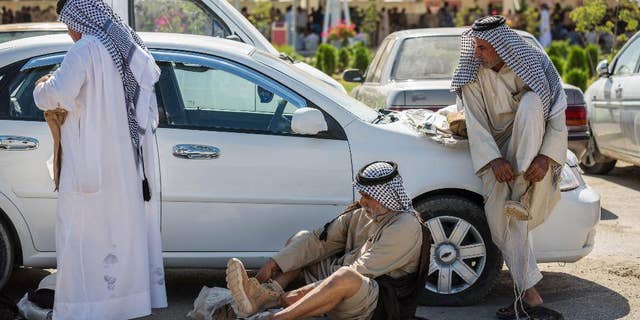 Members of an Iraqi volunteer force put on their newly issued boots in the Shiite holy city of Karbala, 50 miles (80 kilometers) south of Baghdad, Iraq, Tuesday, June 24, 2014. Iraq's top Kurdish leader warned visiting Secretary of State John Kerry on Tuesday that a rapid Sunni insurgent advance has already created "a new reality and a new Iraq," signaling that the U.S. faces major difficulties in its efforts to promote unity among the country's divided factions. The U.N., meanwhile, said more than 1,000 people, most civilians, have been killed in Iraq so far this month, the highest death toll since the U.S. military withdrew from the country in December 2011. (AP Photo/Ahmed al-Husseini)