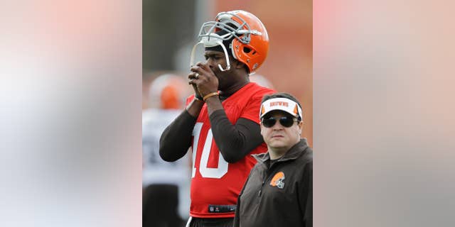 Cleveland Browns quarterback Vince Young warms his hands during a voluntary minicamp workout at the NFL football team's facility in Berea, Ohio Thursday, May 1, 2014. (AP Photo/Mark Duncan)