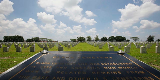 FILE - In this In this July 1, 2011 file photo, a Clark Veterans Cemetery marker faces more than 8,000 tombstones at the sprawling Clark Economic Zone, a former U.S. Air Force base in Dau, Pampanga province in northern Philippines. U.S. and Philippine officials signed an agreement Monday, Dec. 16, 2013, allowing Washington to restore the cemetery where the graves of thousands of American servicemen and dependents have been covered in ash since Mount Pinatubo's 1991 eruption. (AP Photo/Bullit Marquez, File)