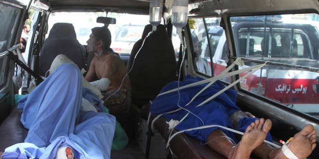 Injured Afghan men lie in an ambulance after an accident on the main highway linking the capital, Kabul, to the southern city of Kandahar, in Ghazni province eastern of Kabul, Afghanistan, Sunday, May 8, 2016. Officials say two buses and a fuel tanker have collided on a major highway in Afghanistan, killing at least 14 people. Dozens more people were wounded in the accident, which set all three vehicles ablaze, and the death toll is expected to rise. (AP Photo/Rahmatullah Nikzad)