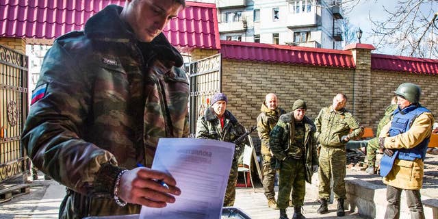 FILE - In this Nov. 2, 2014, file photo, a Pro-Russian rebel commander with the nom de guerre Givi casts his ballot during supreme council and presidential elections on the front line near Donetsk airport in the city of Donetsk, eastern Ukraine. Rebels' Donets News Agency said on Wednesday, Feb. 8, 2017, that Mikhail Tolstykh, better known under his nom de guerre Givi, died early Wednesday morning in what it described as a terrorist attack. Several Russian media outlets said 35-year old Tolstykh died in an explosion in his office. (AP Photo/Dmitry Lovetsky, file)