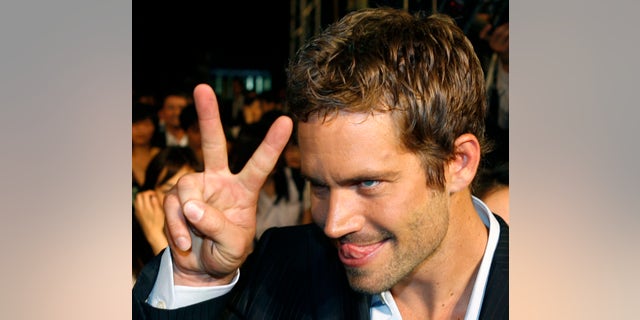 April 15, 2009. Paul Walker gestures to a fan during the premiere of the movie "Fast and Furious 4" in Taipei.