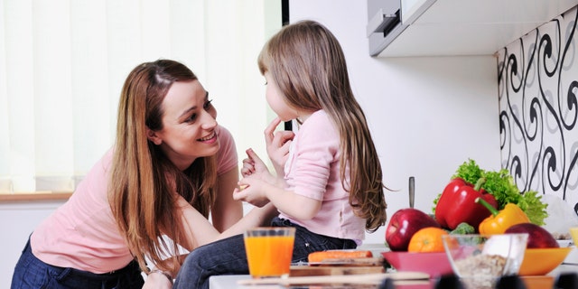 happy young family have lunch time with fresh fruits and vegetable food in bright kitchen