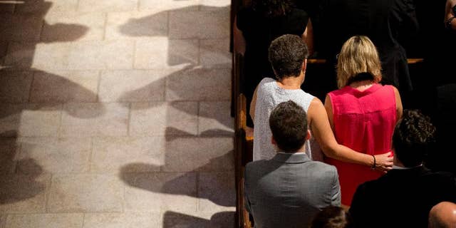 Mourners pray during the funeral service for Christopher Leinonen at the Cathedral Church of St. Luke in Orlando.