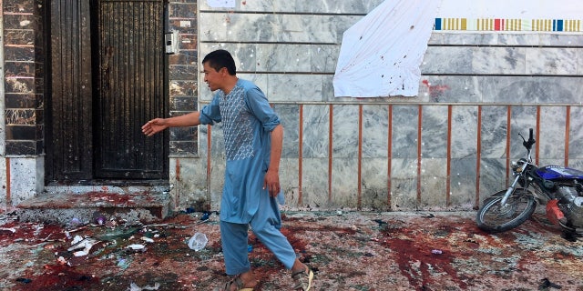 An Afghan man walks outside a voter registration center, which was attacked by a suicide bomber in Kabul, Sunday, April 22, 2018.