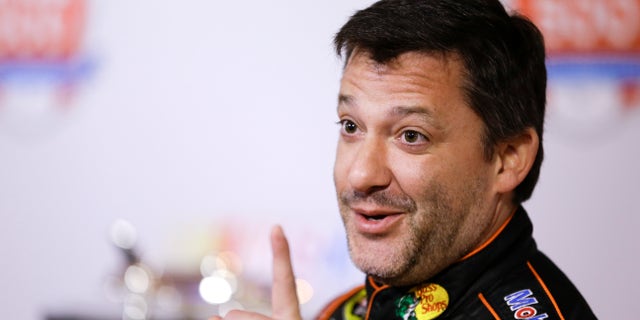 Tony Stewart jokes with members of the media during NASCAR auto racing media day at Daytona International Speedway in Daytona Beach, Fla., Thursday, Feb. 13, 2014. (AP Photo/John Raoux)