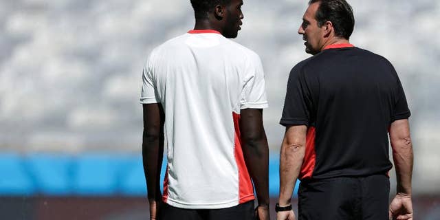 Belgium’s Romelu Lukaku and head coach Marc Wilmots talk at the start of a training session at the Mineirao Stadium in Belo Horizonte, Brazil, Monday, June 16, 2014. Belgium will play in group H of the Brazil 2014 soccer World Cup. (AP Photo/Bruno Magalhaes)