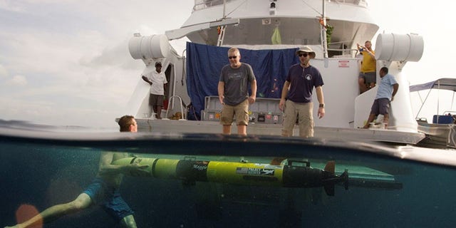 Members of the Project Recover team retrieve a REMUS 100 Autonomous Underwater Vehicle from the water’s of Hansa Bay Papua New Guinea (Project Recover)