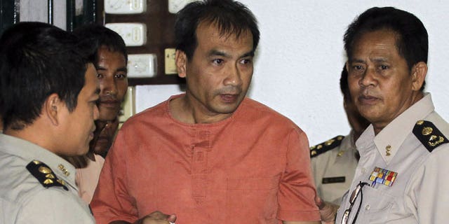 December 8, 2011: Joe Gordon, a Thai-born American, center, is escorted by correction officials at a criminal court in Bangkok, Thailand.