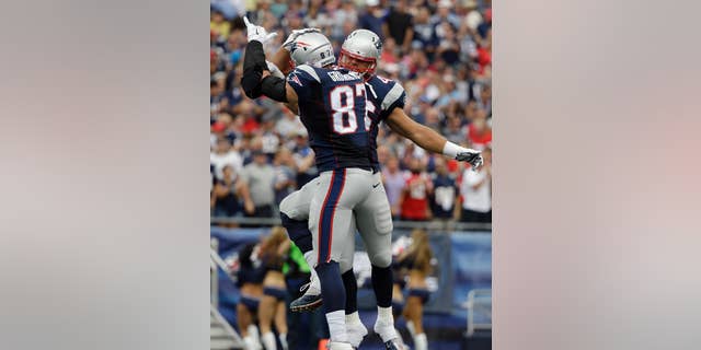 New England Patriots tight end Rob Gronkowski (87) celebrates his touchdown catch with fullback James Develin, rear, in the first half of an NFL football game against the Oakland Raiders, Sunday, Sept. 21, 2014, in Foxborough, Mass. (AP Photo/Steven Senne)