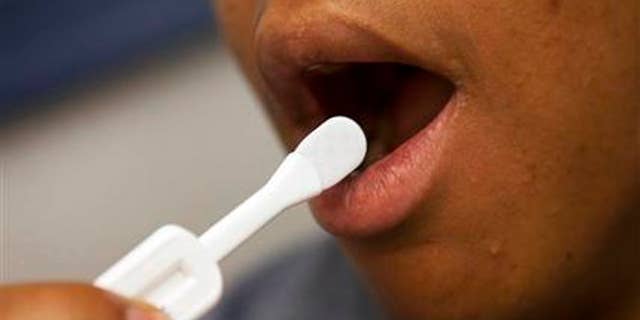 In this photo taken June 27, 2012, Katherine Tapp, 26 of New York City uses an oral test for HIV, inside the HIV Testing Room at the Penn Branch of the District of Columbia Department of Motor Vehicles, in southeast Washington.