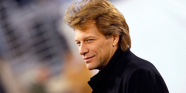 Musician Jon Bon Jovi walks on the field before the NFL football game between the New England Patriots and the New York Jets in East Rutherford, New Jersey, November 13, 2011.