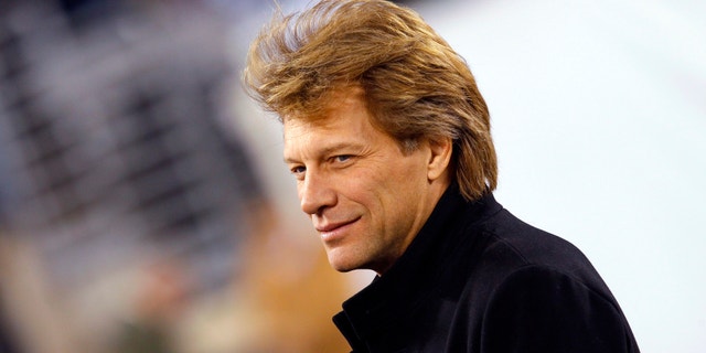 Musician Jon Bon Jovi walks on the field before the NFL football game between the New England Patriots and the New York Jets in East Rutherford, New Jersey, November 13, 2011.