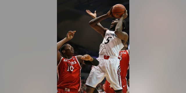 Cincinnati forward Justin Jackson (5) looks to shoot against Rutgers forward Junior Etou (10) during the first half of an NCAA college basketball game, Saturday, Jan. 11, 2014, in Cincinnati. (AP Photo/David Kohl)