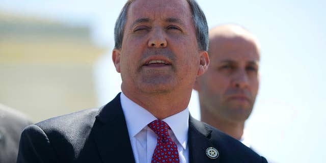File - In this April 18, 2016, file photo, Texas Attorney General Ken Paxton meet with members of the media at the Supreme Court in Washington. A federal judge has dismissed a lawsuit that Texas brought against the federal government in hopes of halting the arrival of Syrian refugees. (AP Photo/Pablo Martinez Monsivais, File)