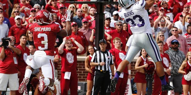 Kansas State defensive back Morgan Burns (33) intercepts a pass intended for Oklahoma wide receiver Sterling Shepard (3) in the third quarter of an NCAA college football game in Norman, Okla., Saturday, Oct. 18, 2014. Kansas State won 31-30. (AP Photo/Sue Ogrocki)