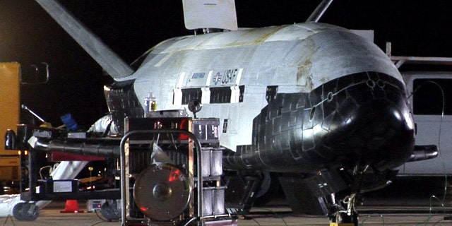 Despite its robotic nature, the X-37B space plane received a warm welcome from Air Force crews at Vandenberg. Here, the vehicle appears to be undergoing safing procedures after landing on Dec. 3 at 1:16 a.m. PST (0916 GMT). Significant weathering, or discoloration, can be seen on the spacecraft's upper thermal blanket insulation.