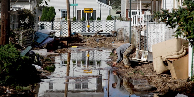 Nov. 2, 2012: A man rinses his hands in flood water while cleaning out a house in a hard-hit neighbor hood in Staten Island, N.Y.