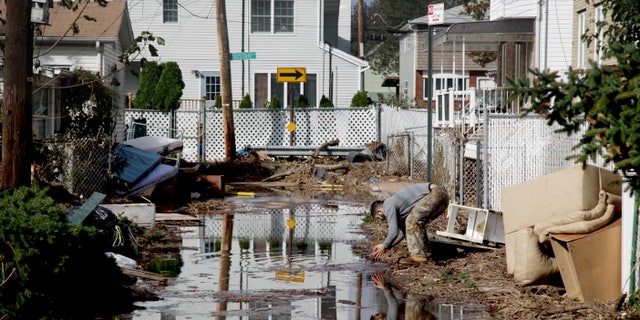 Nov. 2, 2012: A man rinses his hands in flood water while cleaning out a house in a hard-hit neighbor hood in Staten Island, N.Y.