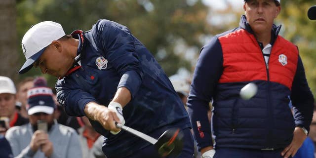United States' Phil Mickelson watches as United States' Rickie Fowler drives on the sixth hole during a practice round for the Ryder Cup golf tournament Tuesday, Sept. 27, 2016, at Hazeltine National Golf Club in Chaska, Minn. (AP Photo/Chris Carlson)