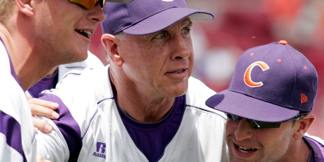 FILE - In this May 31, 2013, file photo, Clemson's coach Jack Leggett huddles witgh his players Joseph Moorefield left, and Scott Firth, right, before the start of an NCAA college baseball regional tournament game against Liberty in Columbia, S.C. Leggett will have the Tigers shooting for Omaha once more when the team opens training camp Saturday. (AP Photo/Mary Ann Chastain, File)