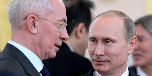 Russian President Vladimir Putin, right, and Ukrainian Prime Minister Mykola Azarov speak before a meeting of the Eurasian Economic Community in the Kremlin in Moscow, Tuesday, Dec. 24, 2013. (AP Photo/RIA-Novosti, Alexei Nikolsky, Presidential Press Service)
