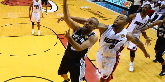 San Antonio Spurs guard Tony Parker (9) goes to the basket as Miami Heat forward Rashard Lewis (9) defends in the first half in Game 4 of the NBA basketball finals in Miami, Thursday, June 12, 2014. The Spurs won 107-86. (AP Photo/, Larry W. Smith, Pool)