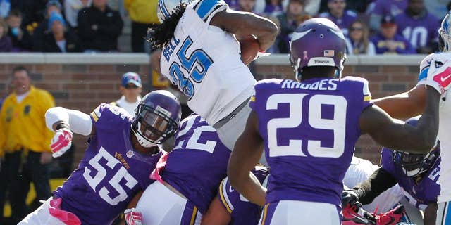 Detroit Lions running back Joique Bell (35) leaps over the Minnesota Vikings defensive line to score from the 1-yard line during the second half of an NFL football game Sunday, Oct. 12, 2014, in Minneapolis. (AP Photo/Ann Heisenfelt)