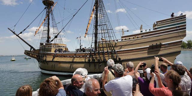 People on a wharf watch as the Mayflower II arrives in Plymouth Harbor on June 6, 2016. It is a  replica, built in 1957, of the famed ship that carried the Pilgrims to Massachusetts in 1620.
