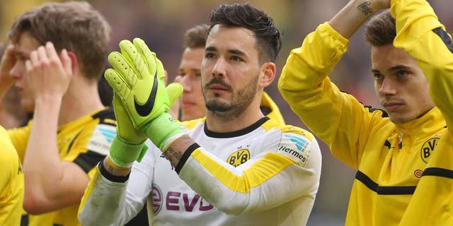 FILE - In this April 15, 2017 photo Dortmund's goalkeeper Roman Buerki und Raphael Guerreiro, right, cheer towards their fans after the German Bundesliga soccer match between Borussia Dortmund and Eintracht Frankfurt in Dortmund, Germany. Borussia Dortmund goalkeeper Roman Buerki says he’s still having trouble sleeping after the attack on his team’s bus on April 11, and says he couldn’t concentrate properly in the delayed Champions League match a day later. (Ina Fassbender/dpa via AP,file)