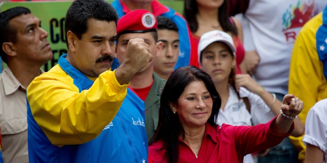 FILE - In this Oct. 18, 2014 file photo, Venezuela's President Nicolas Maduro and first lady Cilia Flores, greet supporters as they arrive for a march for peace in Caracas, Venezuela. Two nephews of Venezuela's powerful first lady Cilia Flores were arrested in Haiti on charges of conspiring to smuggle 800 kilograms of cocaine into the U.S. and will be arraigned in New York, three people familiar with the case said Wednesday, Nov. 11, 2015. (AP Photo/Fernando Llano, File)