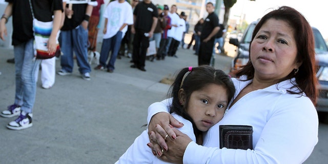 OAKLAND, CA - APRIL 30:  A woman embraces her child as they watch the group "Youth United For Justice" protest Arizona's new immigration law April 30, 2010 in Oakland, California. Dozens of people marched in protest of Arizona state bill 1070 which was signed into law this past week and gives law enforcement officials unprecedented authority to stop and question  suspected illegal immigrants.  (Photo by Justin Sullivan/Getty Images)