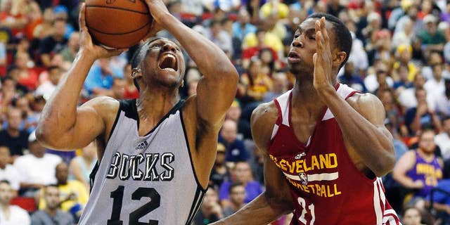 Jabari Parker (12) of the Milwaukee Bucks drives by Andrew Wiggins of the Cleveland Cavaliers in an NBA summer league basketball Friday, July 11, 2014, in Las Vegas. (AP Photo/John Locher)