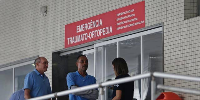 FILE - In this  June 19, 2016, file photo, employees stand in front an emergency entrance at the Souza Aguiar Hospital, in Rio de Janeiro, Brazil. Brazilian police announced Monday, Sept. 26, that they have shot dead a suspected drug trafficker who stunned Rio de Janeiro by pulling off the violent escape from the hospital. (AP Photo/Silvia Izquierdo, File)