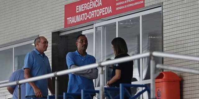 FILE - In this June 19, 2016, file photo, employees stand in front an emergency entrance at the Souza Aguiar Hospital, in Rio de Janeiro, Brazil. Brazilian police announced Monday, Sept. 26, that they have shot dead a suspected drug trafficker who stunned Rio de Janeiro by pulling off the violent escape from the hospital. (AP Photo/Silvia Izquierdo, File)