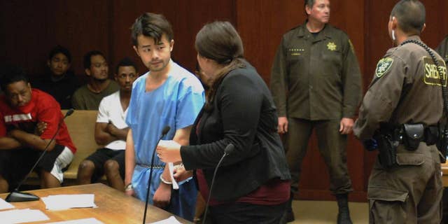 Yu Wei Gong, left, speaks to Deputy Public Defender Diamond Grace in court in Honolulu on Monday, April 17, 2017. The Hawaii man accused of killing his mother months ago stuffed her decapitated head and dismembered body parts in several plastic bags in the refrigerator freezer of the Waikiki apartment they shared, according to court documents made public ahead of the suspect's first court appearance. (AP Photo/Jennifer Sinco Kelleher)