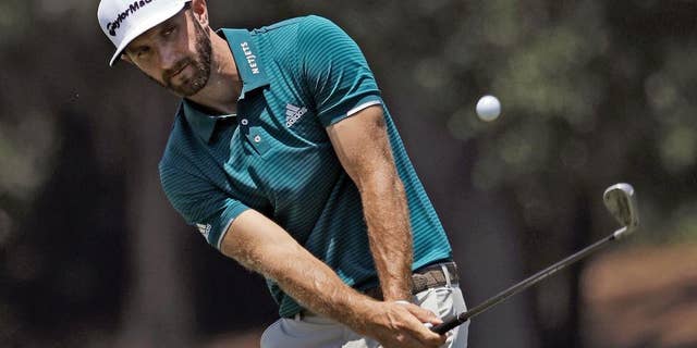 Dustin Johnson chipping onto the seventh green during a practice round for The Players Championship golf tournament in 2017, in Ponte Vedra Beach, Fla. (AP Photo/Chris O'Meara)
